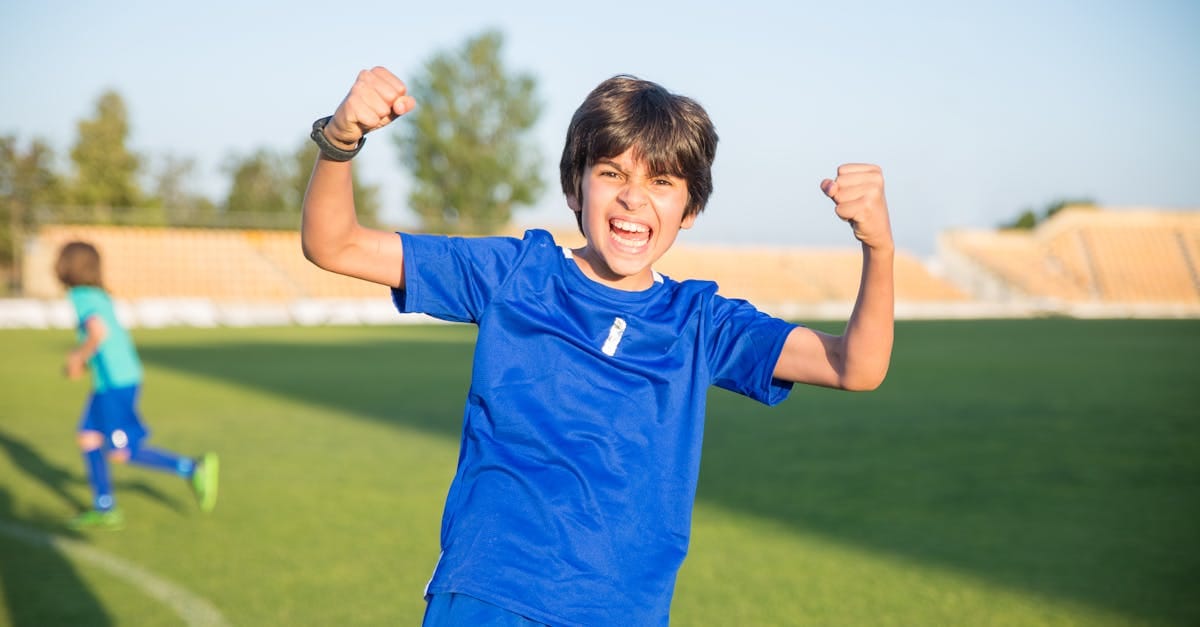 Joyful boy celebrating a soccer win outdoors in Portugal.